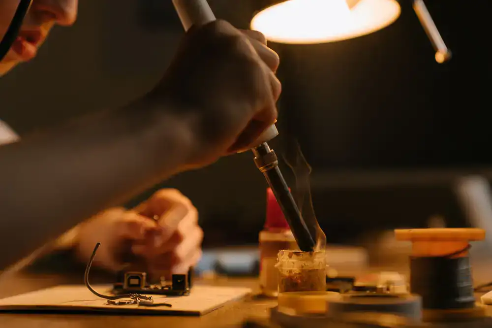 Close up of wires being soldered to a track bus